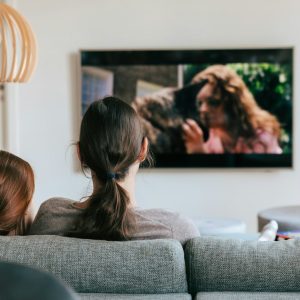 a couple of women sitting on top of a couch